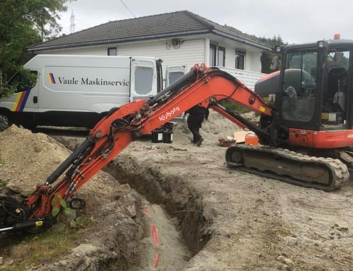 Kubota gravemaskin i arbeid med servicebilen i bakgrunnen